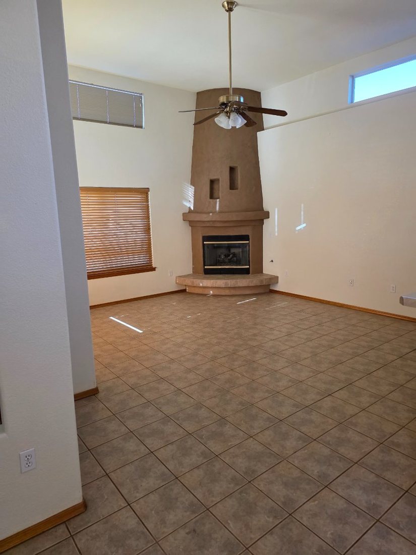 Empty living room with corner fireplace before home staging in Las Cruces