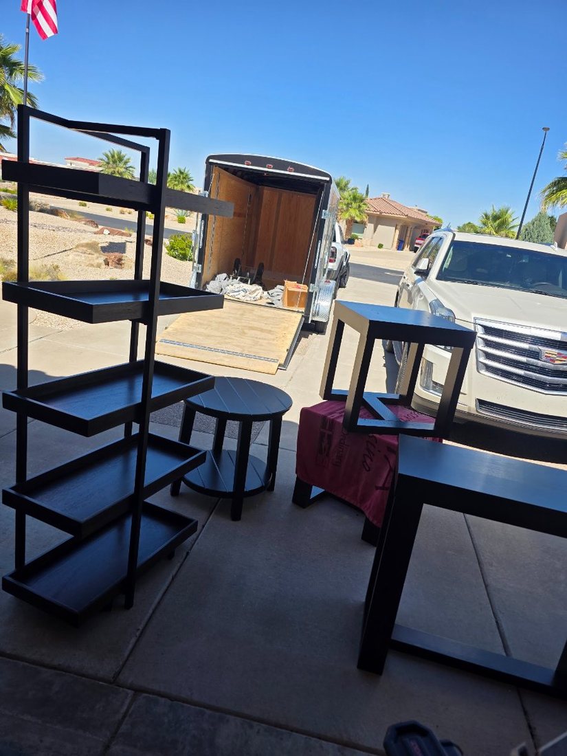 Staging furniture unloaded onto the driveway beside the trailer