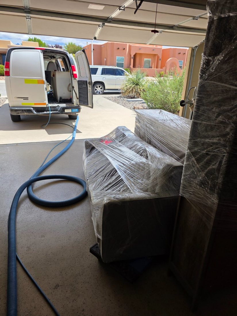 Staging van backed into the garage with wrapped furniture coming off, Las Cruces