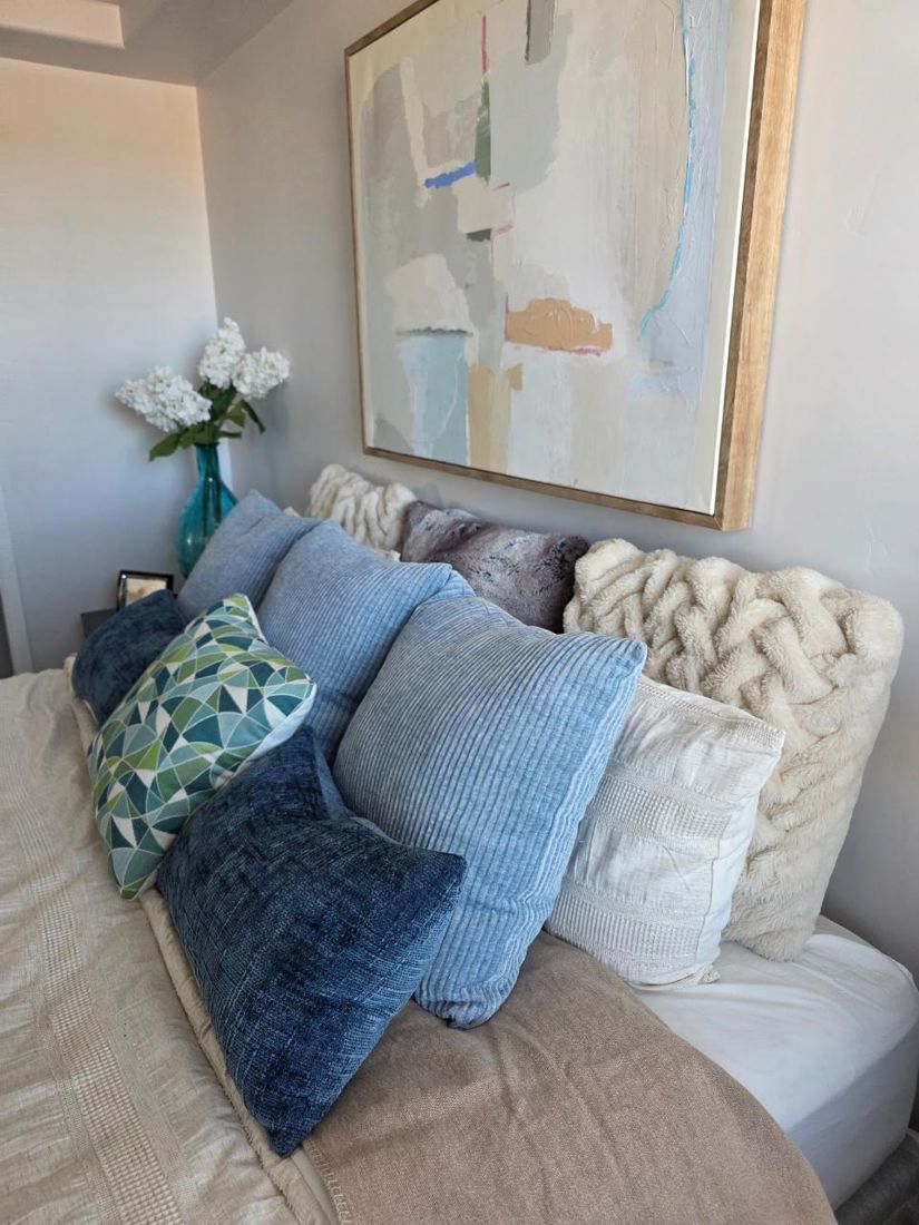 Styled bed with layered pillows and art, home staging Las Cruces