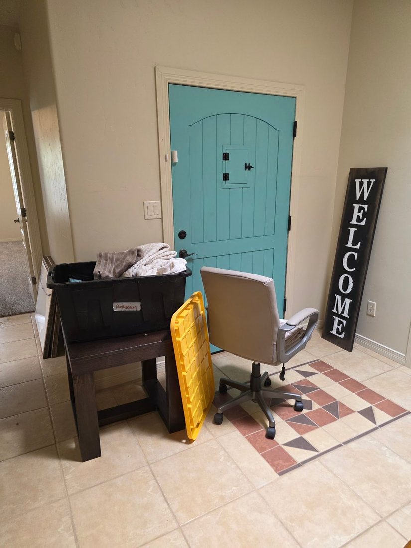 Desk, chair, bins and a welcome sign carried in through the front entry