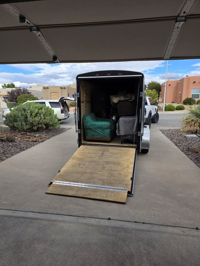 Unloading staging furniture down the trailer ramp in Las Cruces