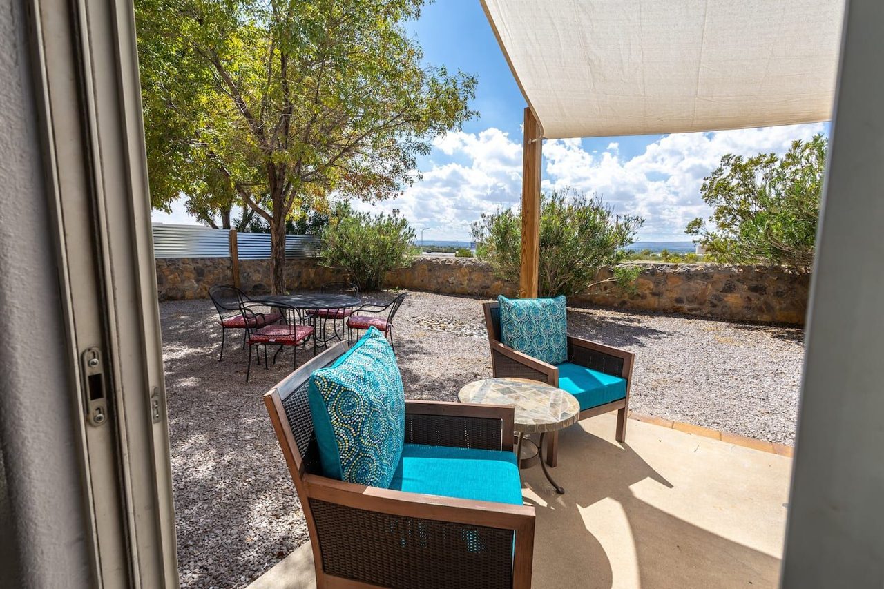 Shaded backyard patio with turquoise chairs and bistro table, Kingston House Las Cruces