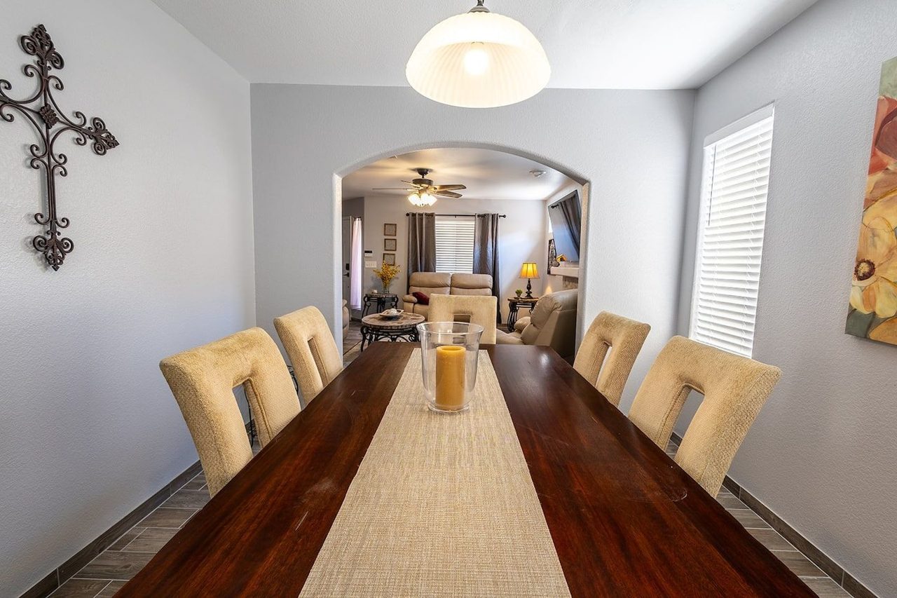 Dining room with long wood table and upholstered chairs, Kingston House Las Cruces
