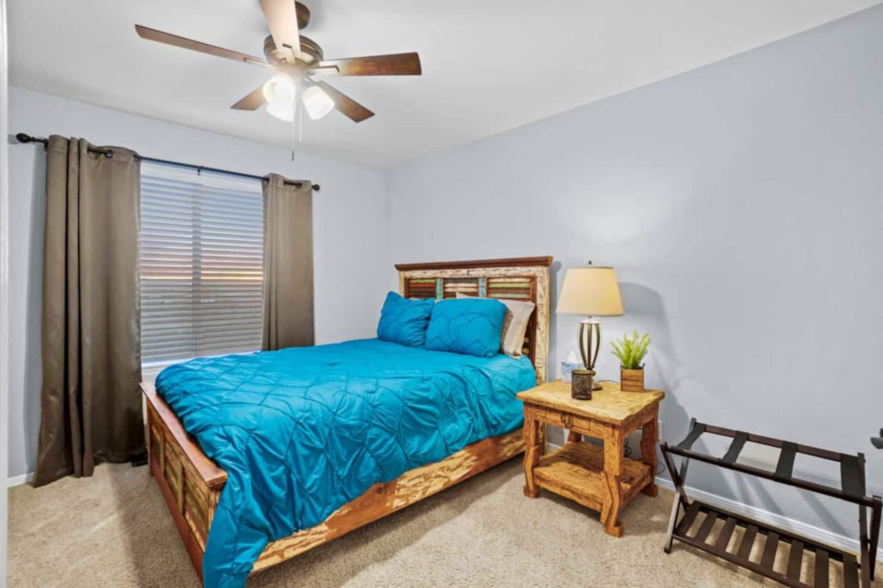 Guest bedroom with rustic wood bed and turquoise bedding, Kingston House Las Cruces