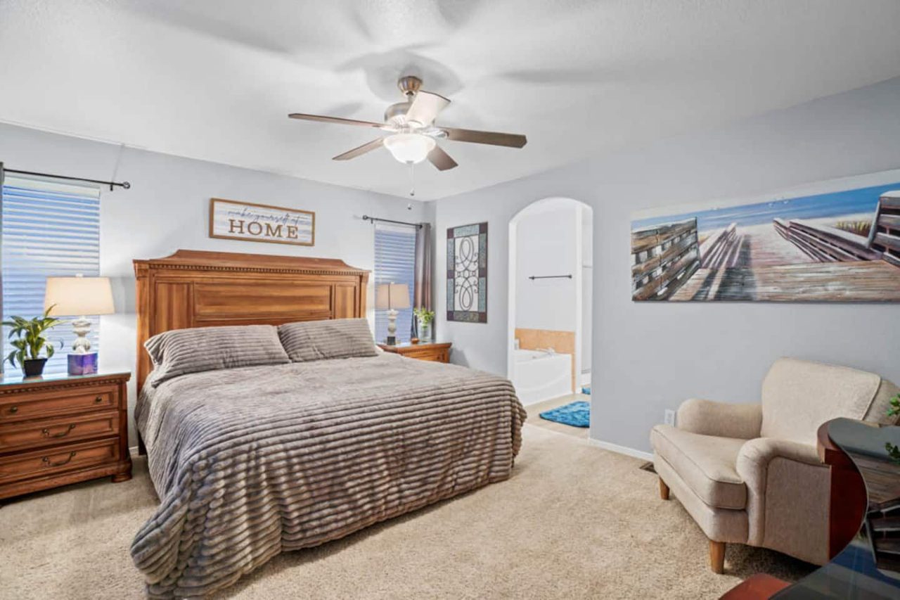 Primary bedroom with king bed, reading chair and wall art, Kingston House Las Cruces