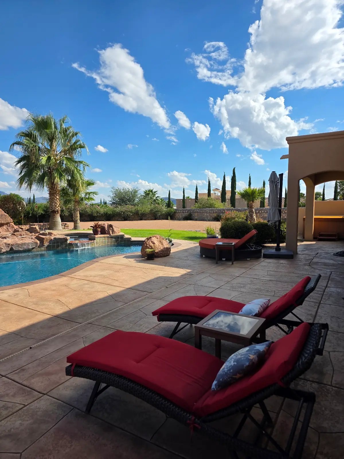 Poolside outdoor staging with red loungers, Las Cruces NM