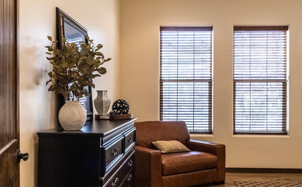 Staged bedroom with dresser, décor and leather chair, Sedona Boulders Las Cruces