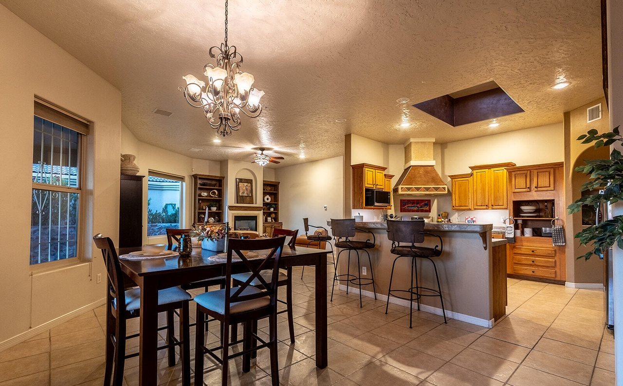 Staged dining table and bar stools opening to the kitchen, Sedona Hills Las Cruces