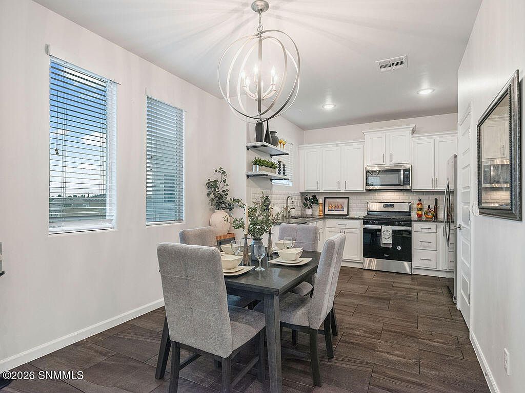 Staged dining room with chandelier opening to the kitchen, Las Cruces home staging