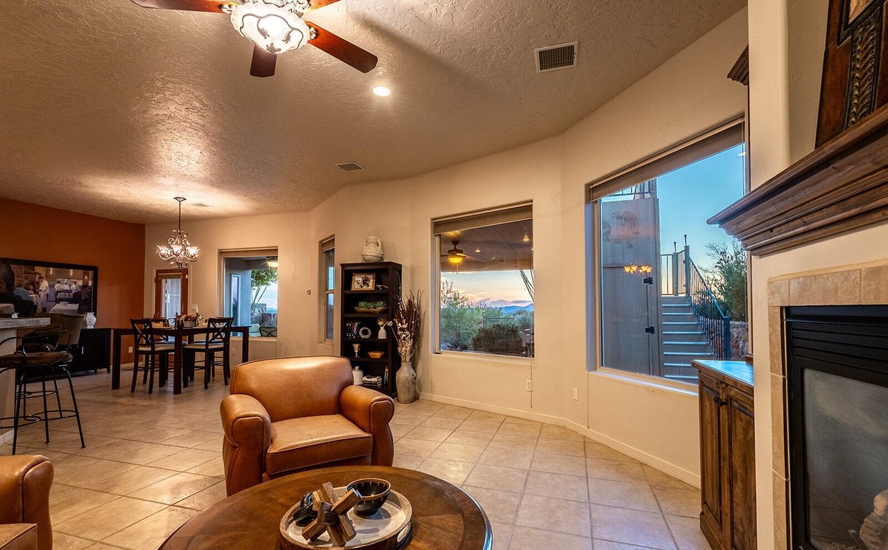 Staged great room with leather club chairs, fireplace and dining area beyond, Sedona Hills home staging Las Cruces NM