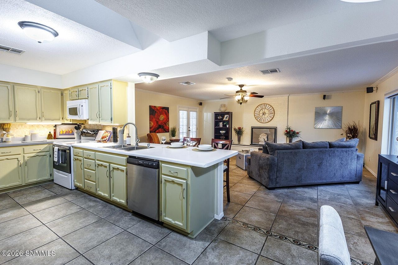 Staged kitchen island opening to a furnished family room in Las Cruces