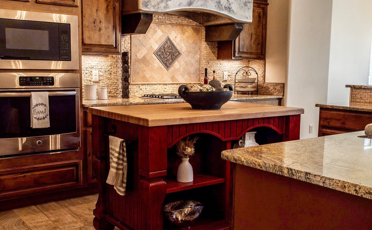 Staged kitchen with red island, wall ovens and tile backsplash, Sedona Boulders Las Cruces
