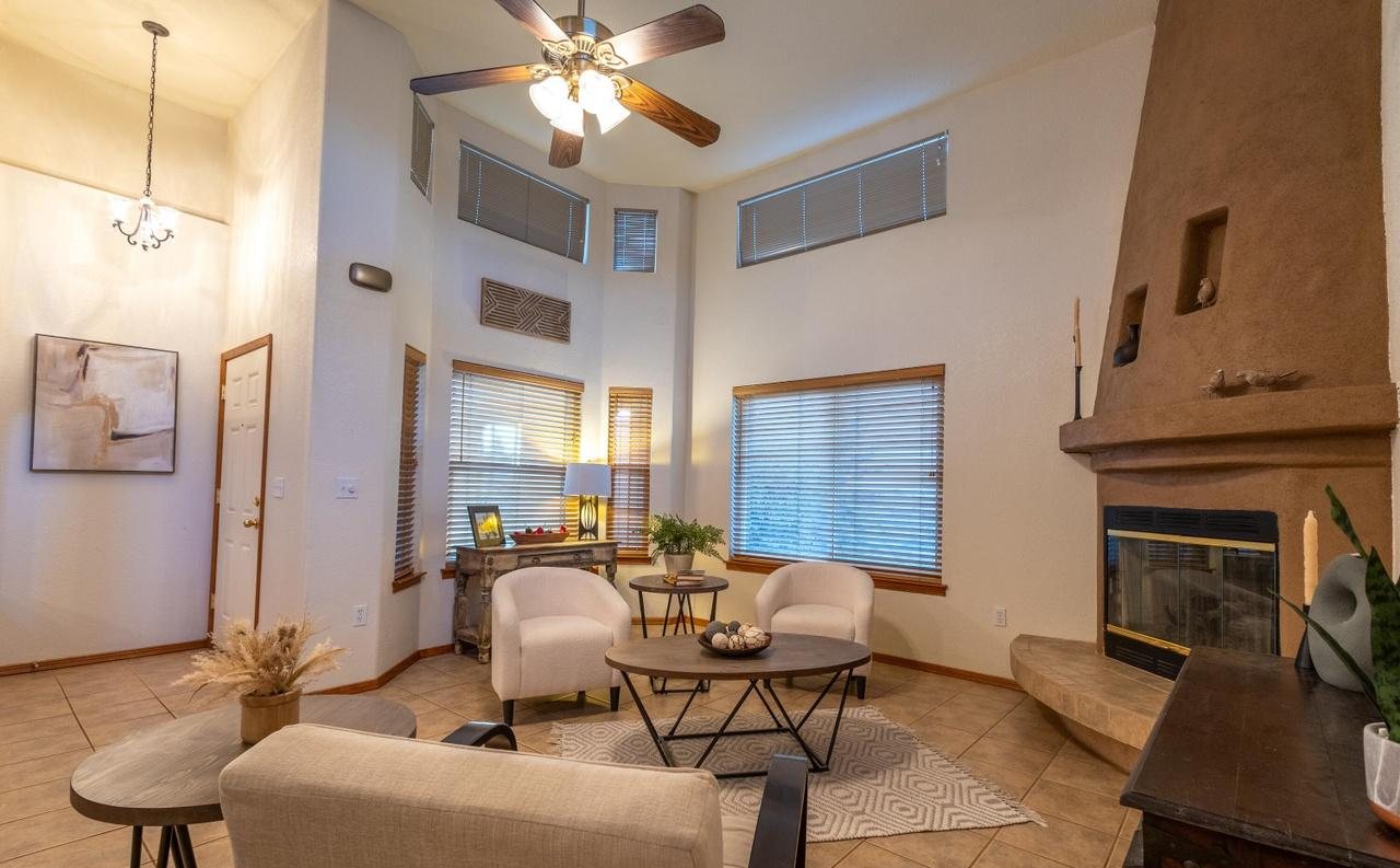 Staged living room with cream chairs, coffee table and corner fireplace, Foxtail Pine home staging Las Cruces NM