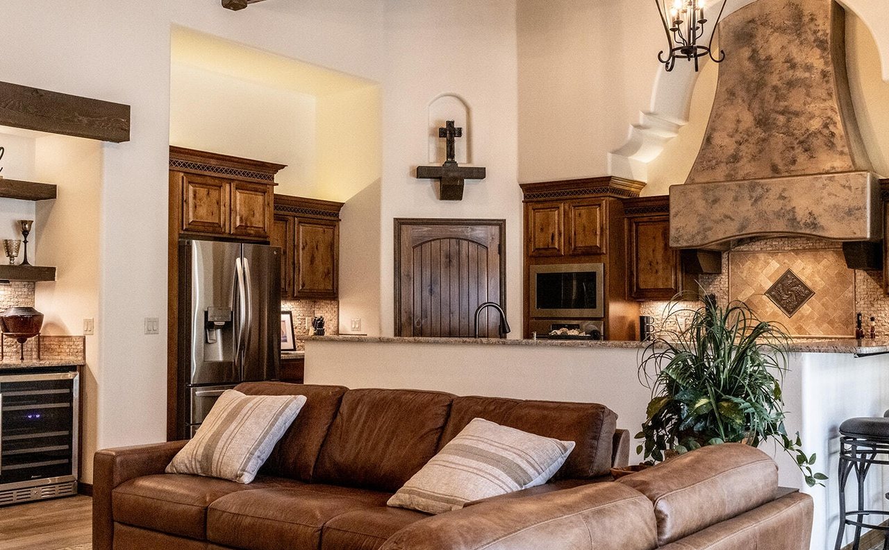 Staged living room with leather sofas and open kitchen, Sedona Boulders home staging Las Cruces NM