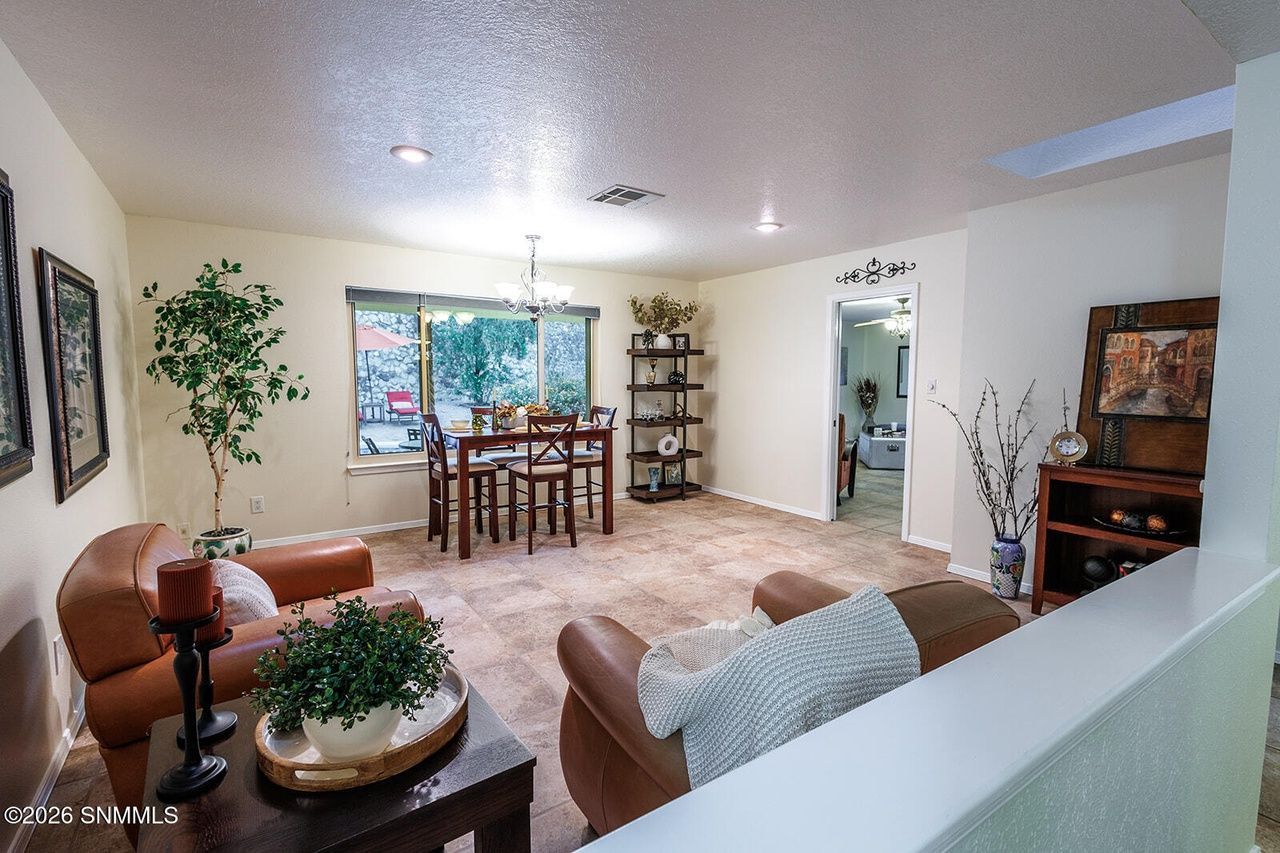 Staged living room with leather sofas and dining area beyond, home staging at 1724 Salinas Drive, Las Cruces NM