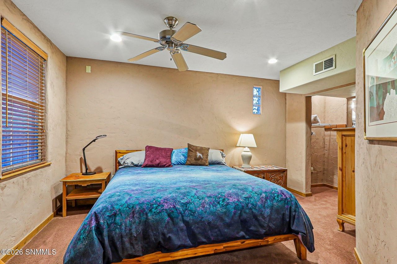 Guest bedroom with made bed and nightstand lamp, Las Cruces NM home