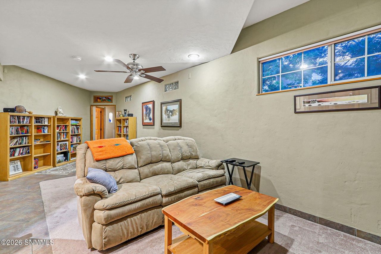 Furnished living room with sofa and bookshelves at 5093 Black Quartz Road, Las Cruces NM